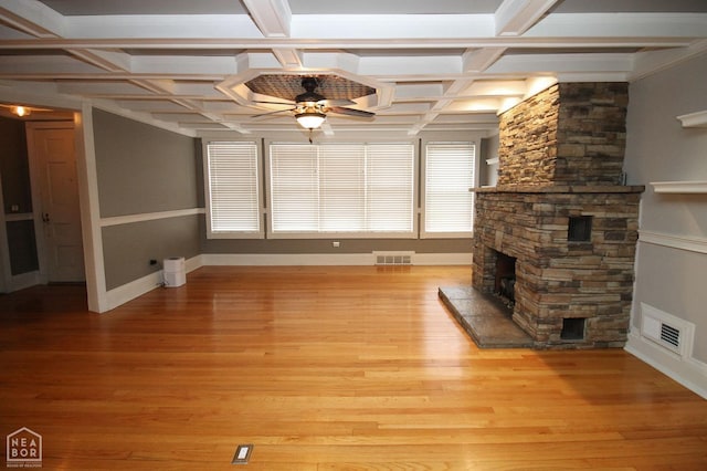 unfurnished living room with light wood-style flooring, a fireplace, a ceiling fan, and visible vents