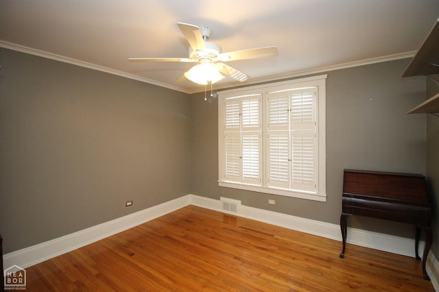 unfurnished room with visible vents, baseboards, ornamental molding, a ceiling fan, and wood finished floors