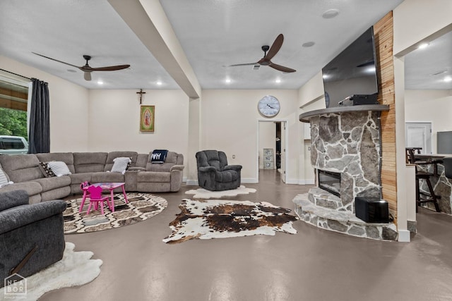 living room featuring a fireplace, concrete flooring, and ceiling fan