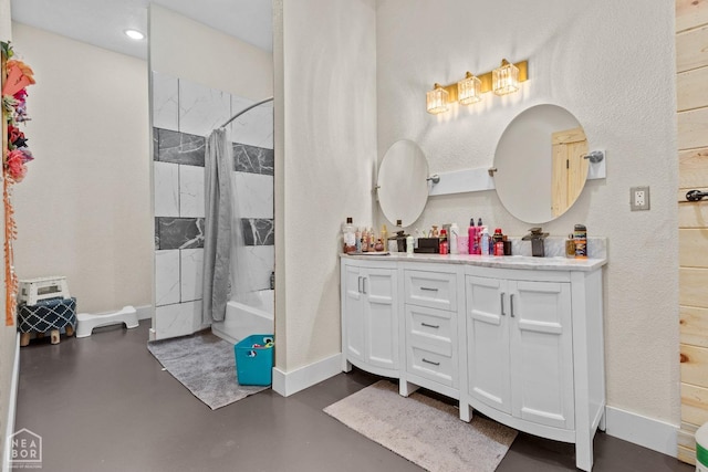 bathroom with shower / tub combination, double vanity, concrete flooring, and baseboards