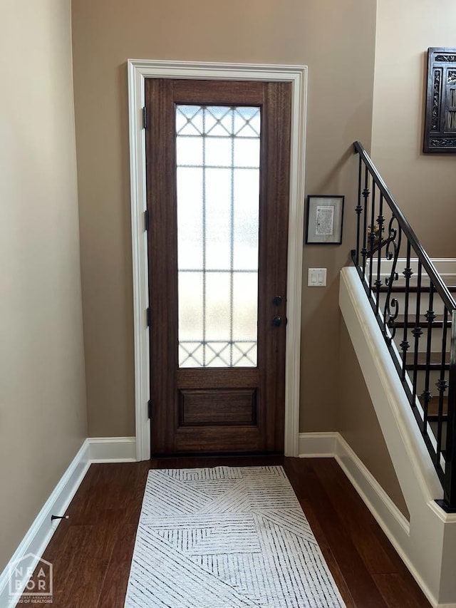 entrance foyer featuring baseboards, stairs, and dark wood-style floors