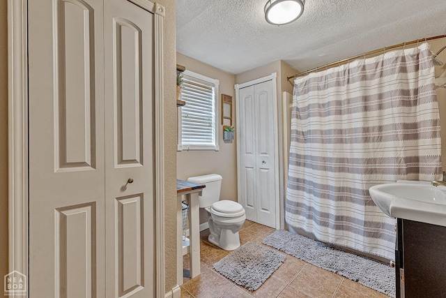 215 N Nance St, Monette, AR 72447 - full bath featuring toilet, a textured ceiling, a closet, vanity, and tile patterned flooring