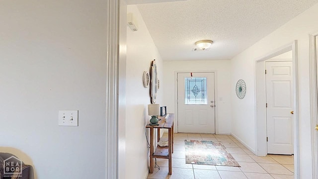 2316 Sheffield Dr, Jonesboro, AR 72405 - foyer with light tile patterned floors, a textured ceiling, and baseboards