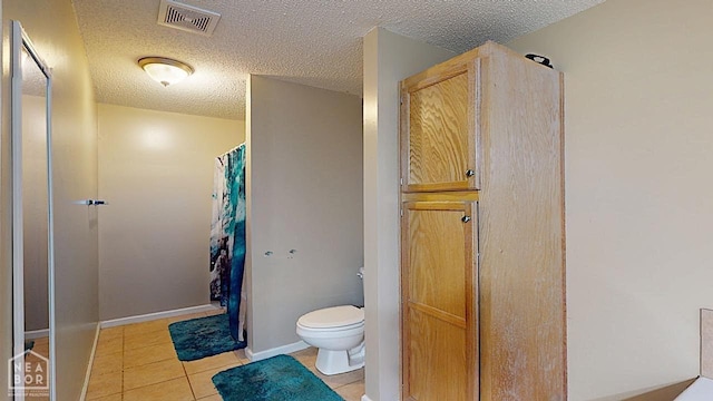 2316 Sheffield Dr, Jonesboro, AR 72405 - bathroom featuring toilet, a textured ceiling, tile patterned floors, and curtained shower