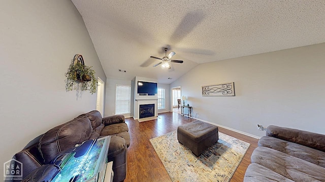 2316 Sheffield Dr, Jonesboro, AR 72405 - living area with a ceiling fan, lofted ceiling, a fireplace with flush hearth, dark wood finished floors, and a textured ceiling