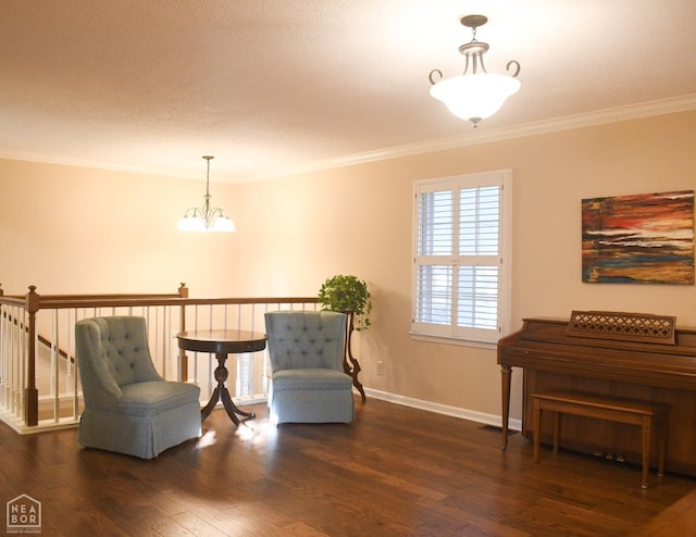 living area with a notable chandelier, baseboards, crown molding, and wood finished floors