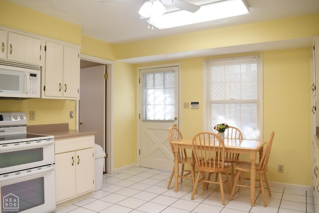 kitchen featuring white cabinets, white appliances, light tile patterned flooring, and ceiling fan