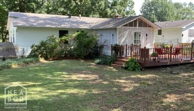 back of property featuring a yard and a wooden deck