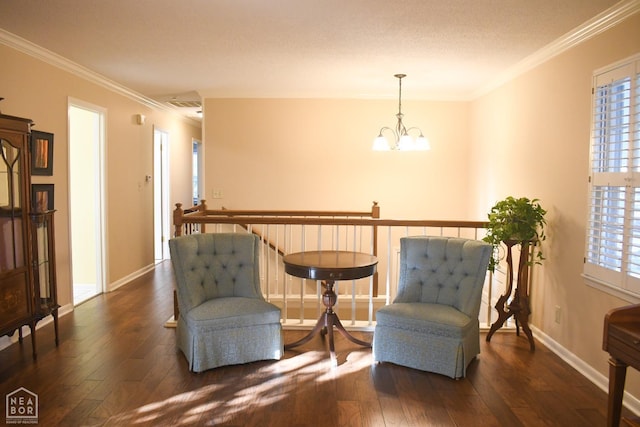 living area with a chandelier, hardwood / wood-style floors, ornamental molding, and a healthy amount of sunlight
