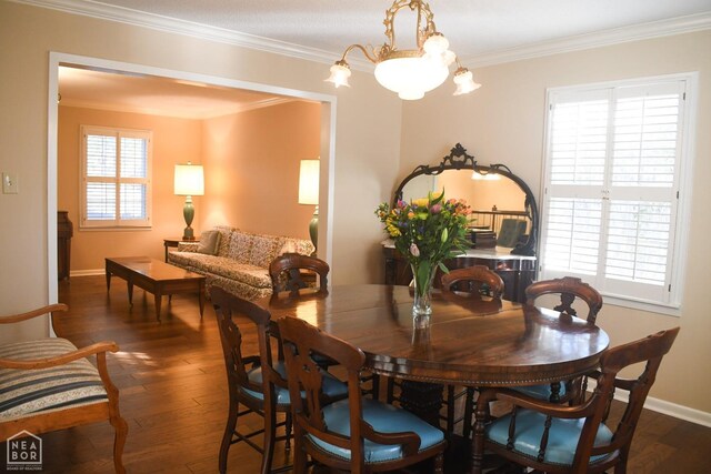 dining space featuring a chandelier, hardwood / wood-style floors, crown molding, and baseboards