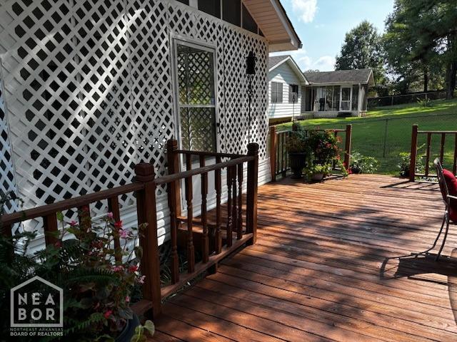 wooden terrace featuring a lawn