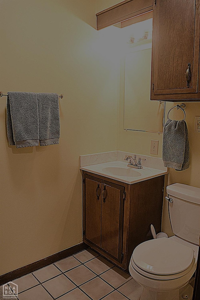 bathroom with tile patterned flooring, vanity, baseboards, and toilet