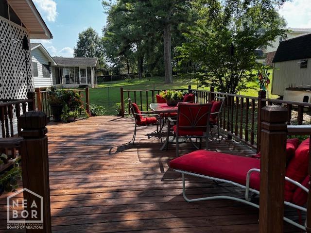deck featuring a yard and outdoor dining area