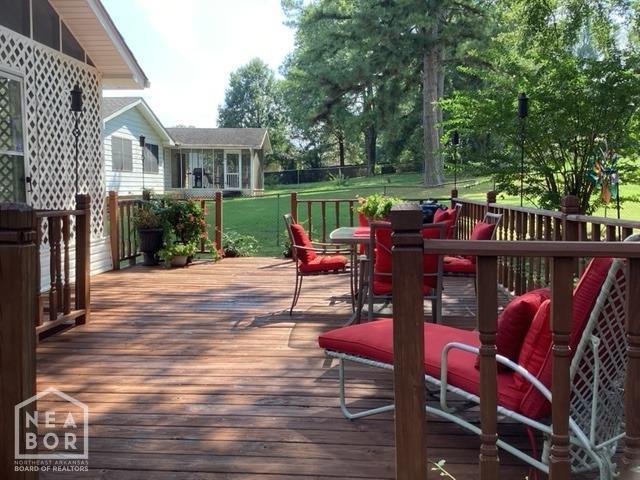 deck featuring outdoor dining space and a yard