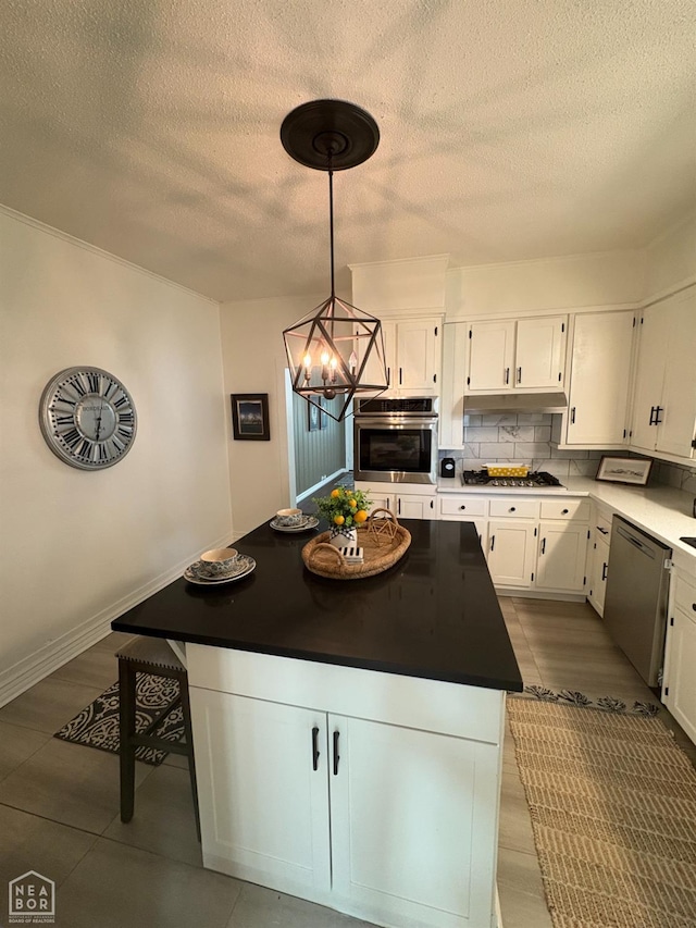 608 W Poplar St W, Paragould, AR 72450 - kitchen with a center island, a textured ceiling, a chandelier, white cabinets, and stainless steel appliances