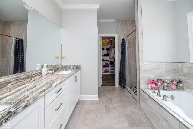 bathroom featuring a spacious closet, crown molding, vanity, a stall shower, and a garden tub