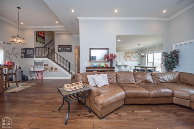living room with wood finished floors, recessed lighting, ornamental molding, and stairs