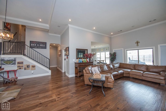 living area featuring a notable chandelier, baseboards, ornamental molding, stairway, and wood finished floors