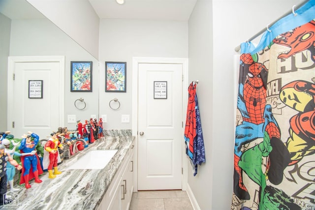 full bath featuring tile patterned flooring, vanity, and baseboards