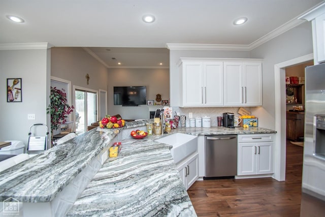 kitchen with tasteful backsplash, white cabinets, dark wood-type flooring, stainless steel appliances, and a sink