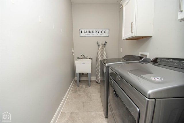 laundry room featuring cabinet space, washing machine and clothes dryer, and baseboards