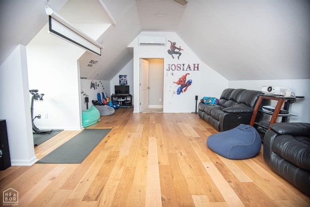 additional living space with wood-type flooring, an AC wall unit, and lofted ceiling