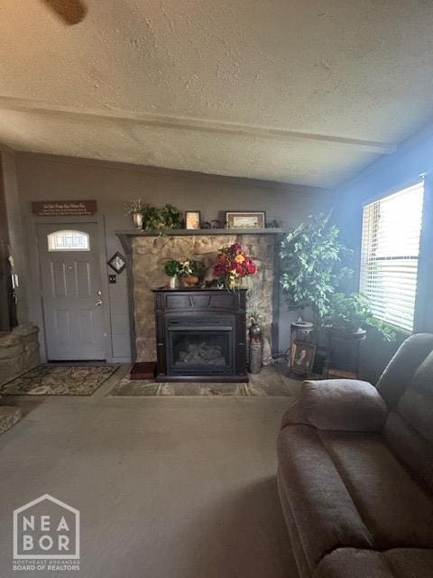 living area featuring vaulted ceiling, a fireplace, and a textured ceiling