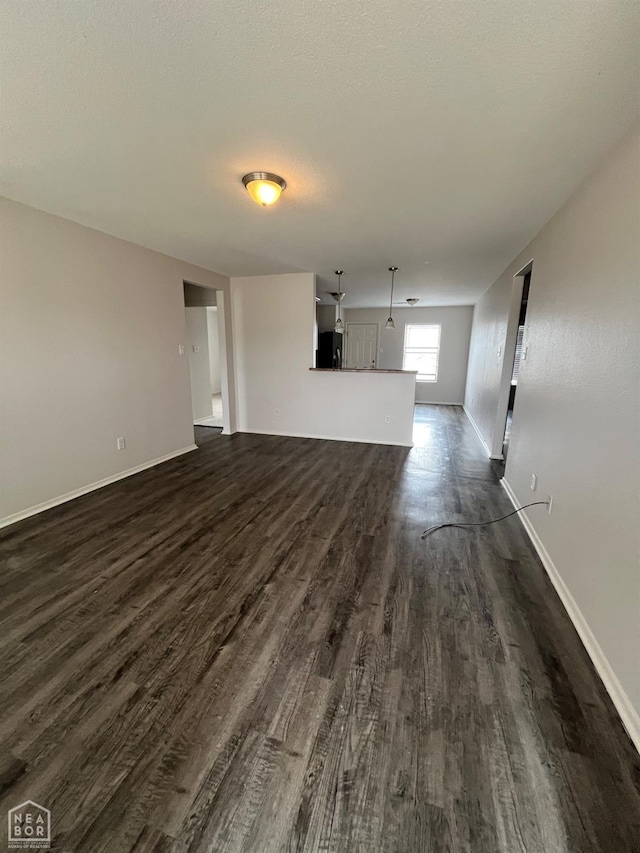 3828 Remington Dr, Jonesboro, AR 72404 - unfurnished living room with baseboards and dark wood-type flooring