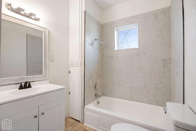 bathroom featuring toilet, washtub / shower combination, vanity, and wood finished floors