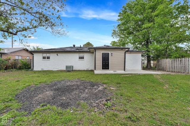 rear view of house featuring a fenced backyard, central AC unit, and a lawn