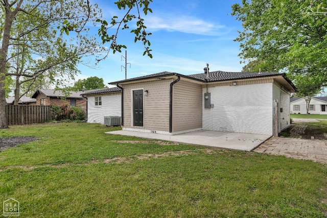back of property featuring fence, a patio, and a yard