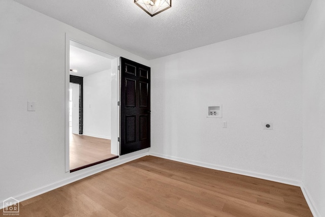 unfurnished room with baseboards, a textured ceiling, and wood finished floors