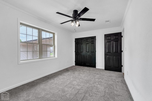 unfurnished bedroom featuring crown molding, baseboards, and carpet floors