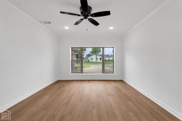 unfurnished room with light wood-style floors, baseboards, ornamental molding, and visible vents