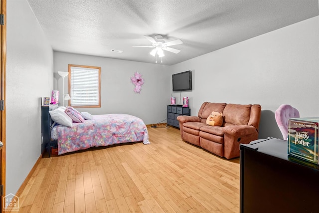 330 Greene 730th Rd, Paragould, AR 72450 - bedroom with light wood-style floors, a textured ceiling, and a ceiling fan