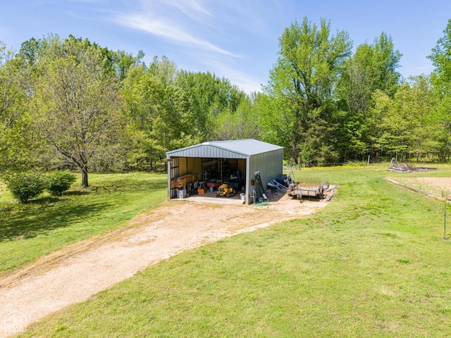 330 Greene 730th Rd, Paragould, AR 72450 - view of green lawn featuring a pole building, an outdoor structure, driveway, and a forest view