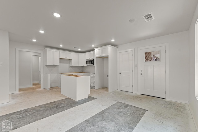 220 Stewart, Monette, AR 72447 - kitchen with stainless steel microwave, a center island, white cabinetry, and recessed lighting