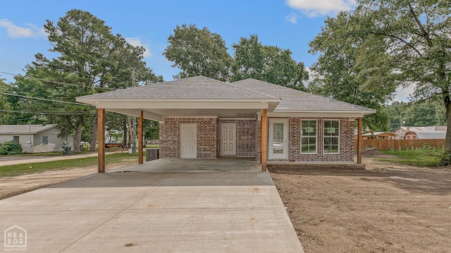 220 Stewart, Monette, AR 72447 - view of front facade with brick siding, driveway, a shingled roof, and a carport