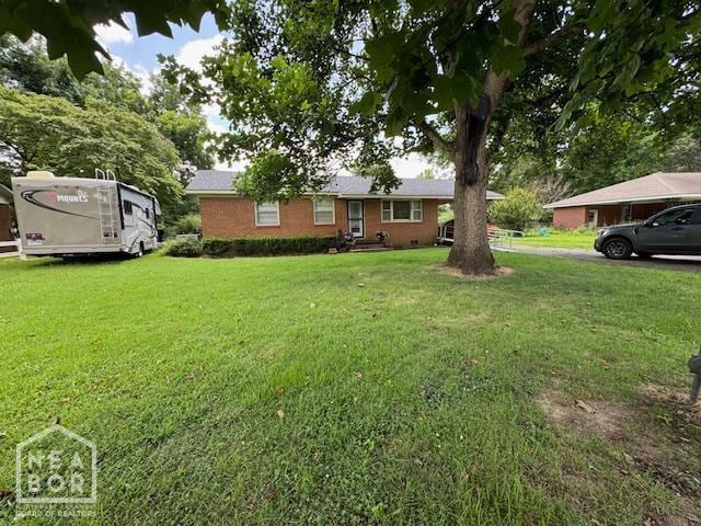 1207 Basil St, Corning, AR 72422 - view of front of house with a front yard and brick siding
