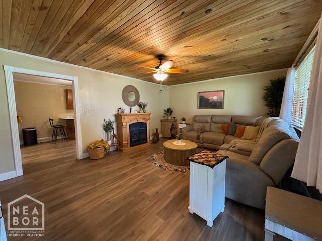 1207 Basil St, Corning, AR 72422 - living room featuring ceiling fan, wooden ceiling, a fireplace, dark wood finished floors, and ornamental molding