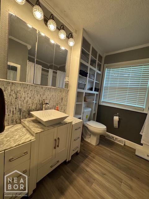 1207 Basil St, Corning, AR 72422 - bathroom featuring wood finished floors, crown molding, a textured ceiling, vanity, and a shower with curtain