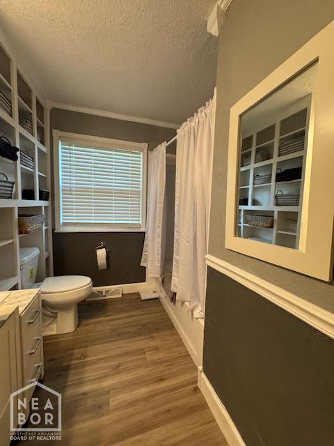 1207 Basil St, Corning, AR 72422 - full bath with wood finished floors, a textured ceiling, a shower with curtain, vanity, and crown molding