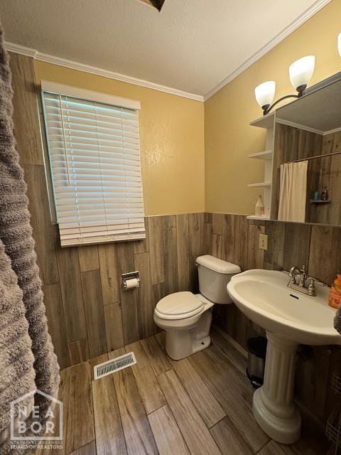 1207 Basil St, Corning, AR 72422 - full bathroom featuring wood finished floors, wainscoting, a shower with shower curtain, and ornamental molding