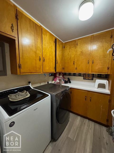 1207 Basil St, Corning, AR 72422 - washroom featuring cabinet space, washing machine and clothes dryer, and light wood-style floors