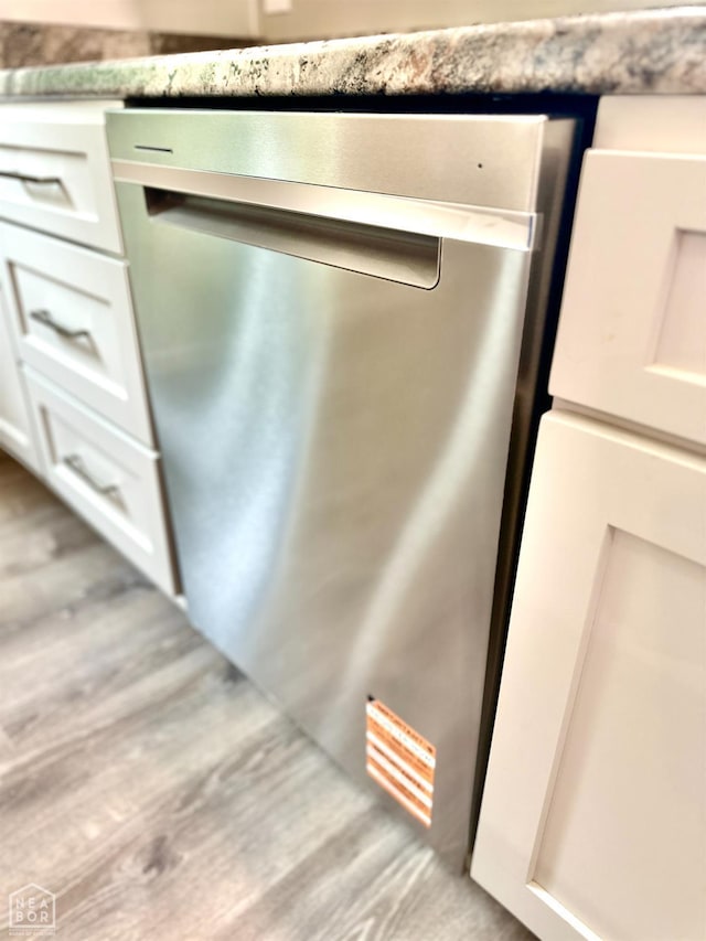 377 N 3rd St, Black Rock, AR 72415 - kitchen view of dishwasher, white cabinetry, and wood finished floors