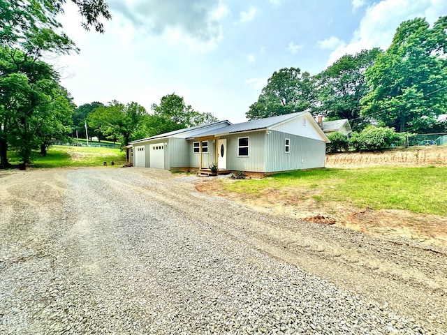 377 N 3rd St, Black Rock, AR 72415 - view of front of house featuring driveway, an attached garage, view of wooded area, and a front yard