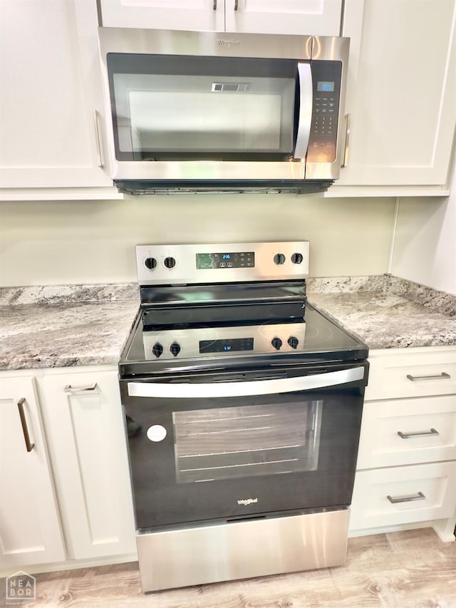 377 N 3rd St, Black Rock, AR 72415 - kitchen featuring stainless steel appliances, white cabinetry, light wood-style flooring, and light stone countertops