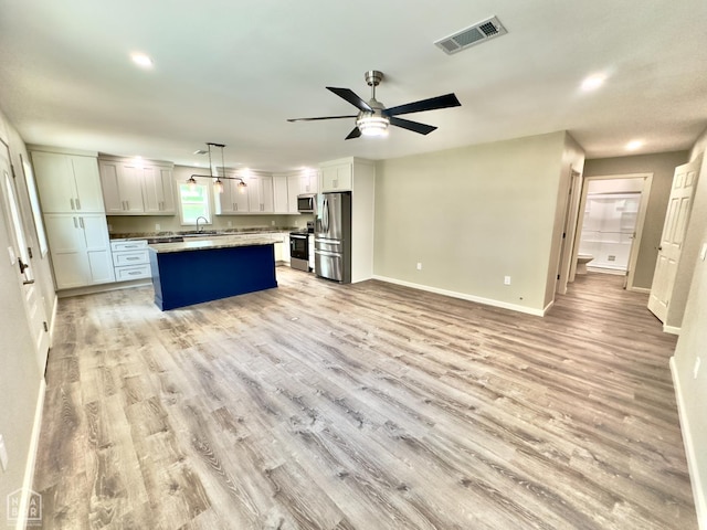 377 N 3rd St, Black Rock, AR 72415 - kitchen featuring appliances with stainless steel finishes, light wood-style flooring, ceiling fan, open floor plan, and hanging light fixtures