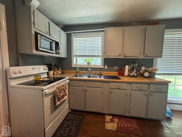 715 S 5th Ave, Paragould, AR 72450 - kitchen featuring white electric range oven, stainless steel microwave, a textured ceiling, light countertops, and dark wood finished floors
