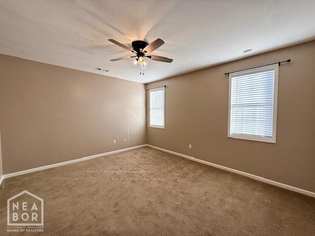 spare room with visible vents, baseboards, carpet, and ceiling fan